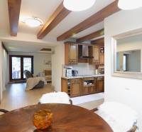 Dining room and kitchen in a family house with wooden beams and a glass display cabinet.