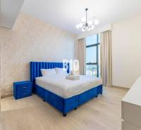 Bedroom in a 3-room apartment with a blue bed, dresser, and modern lighting.