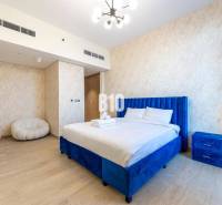 A bedroom with a blue bed and subtly patterned walls in a 3-room apartment.