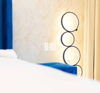 A wall lamp with circular frames by the hangers in a 3-room apartment.
