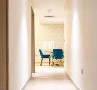 The hallway leads to a room with blue chairs and a patterned wall in a 3-room apartment.
