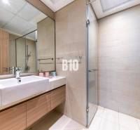 A bathroom with a shower and a mirror in a 3-room apartment.