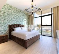 A stylish bedroom with patterned wallpaper and a spacious window in a three-room apartment.