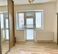 A room in a 3-room apartment with a window and balcony door, built-in wardrobe, light parquet flooring.