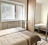 A bedroom in a 3-room apartment with two beds and a built-in wardrobe.