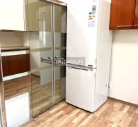 A kitchen with a built-in wardrobe and a refrigerator in a 3-room apartment.