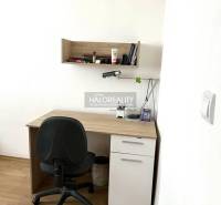 A desk with a shelf and an office chair in a 3-room apartment.