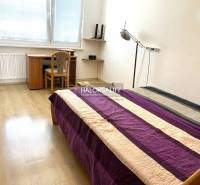 Bedroom in a 3-room apartment with a bed, a desk, and wooden flooring.