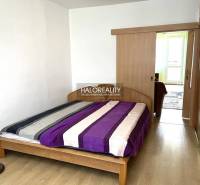 Bedroom in a 3-room apartment with a wooden bed and built-in wardrobes.