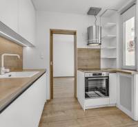 A kitchen with wooden details and built-in appliances in a 4-room apartment.