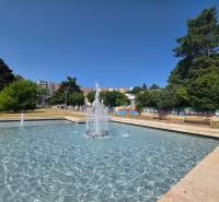 Fountain and benches surrounded by greenery on Landau Street in Bratislava - Dúbravka.