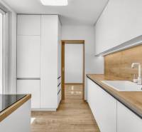 A kitchen in a 4-room apartment with white cabinets and a wooden countertop.