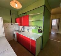 A kitchen in a 3-room apartment with green walls and red cabinets.