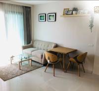 Living room in a two-room apartment with a sofa, table, and dining area.