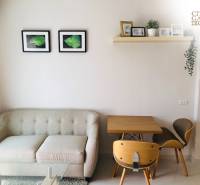 Living area of a 2-room apartment with a sofa, table, and wall decorations.