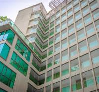 Construction of apartments in Pattaya with a glass facade and balconies in a modern design.