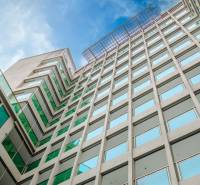 Apartment construction in Pattaya: a modern building with glass windows under an azure sky.