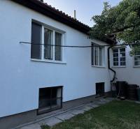 A family house in Lučenec with a white facade, a garden, and large windows.