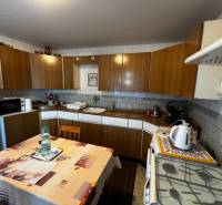 A kitchen in a family house with a wooden cabinet and a dining table.
