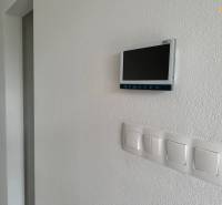 In the family house, there are light switches and a digital display located on the wall.