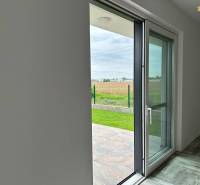 The interior of a family house with a view of the garden through large glass doors.