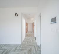 A hallway in a family house with wooden flooring and white walls.