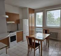 The kitchen in a 2-room apartment with a kitchen unit, table, and chairs.