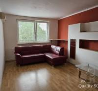 Living room with a corner sofa and a glass table in a 2-room apartment.