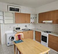 Kitchen in a 2-room apartment with a kitchenette, dining table, and appliances.