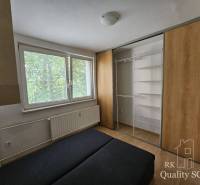Bedroom in a 2-room apartment with a large built-in wardrobe and a radiator under the window.