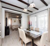 A dining room in a family house with a glass wall and wooden beams.