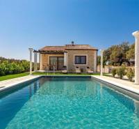 A family house in Bibinje with a pool, columns, and surrounding greenery.