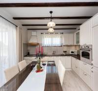 A kitchen in a family house with a dining table and candlesticks on a white table runner.