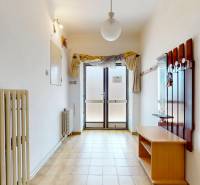 A hallway in a family house with a light, a wall radiator, and an entrance door.