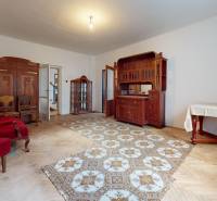 A family house with wooden furniture, a carpet, and chairs in the living room.