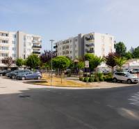 Five-story apartment buildings with parking and greenery in Trenčín near a 2-room apartment.