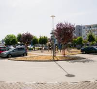Parking lot and modern apartment buildings in Trenčín with a children's playground.