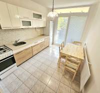 Kitchen in a 3-room apartment with a dining table, gas stove, and refrigerator.