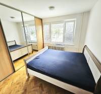 Bedroom in a 3-room apartment with wooden flooring, a large wardrobe, and a bed.