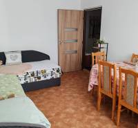 Living room in a 3-room apartment with a dining table and sofas.