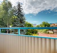 A balcony in a 4-room apartment on Ľ. Štúr Street in Zvolen with a view of greenery.
