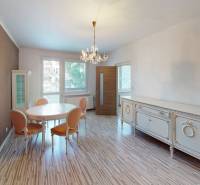 Dining room in a 4-room apartment with a table, chairs, chandelier, and solid furniture.