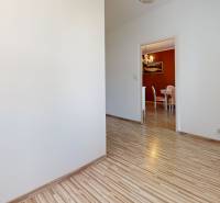 Interior of a 4-room apartment with wooden flooring and a lamp, a dining table is visible.