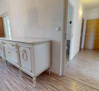 A hallway in a 4-room apartment with wooden doors and a decorative chest of drawers.