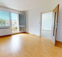 A room with a wooden floor and a large window in a 4-room apartment.