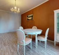 Dining area with chairs and a cabinet in a 4-room apartment, classic wooden floors.