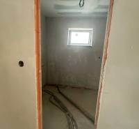 Unfinished room in a family house with a window and prepared electrical installation.