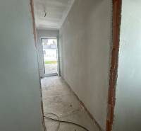 A hallway without finished walls and electrical wiring in a family house.