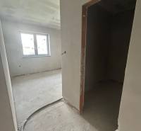 The interior of a family house with unfinished walls and an open window.