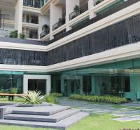 Apartment construction in Pattaya with glass facades and balconies with plants.